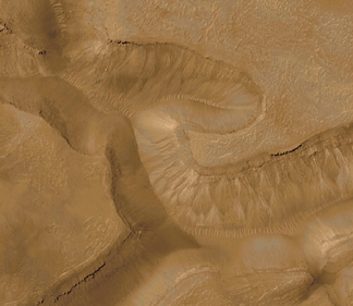 Image taken by the Surveyor MOC camera and shows a series of troughs and layered mesas in the Gorgonum Chaos regions of the martain southern hemisphere.