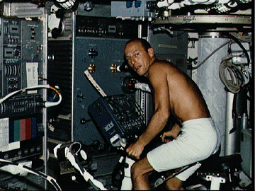 Charles ("Pete") Conrad, Jr. exercises aboard Skylab on the bicycle ergometer.